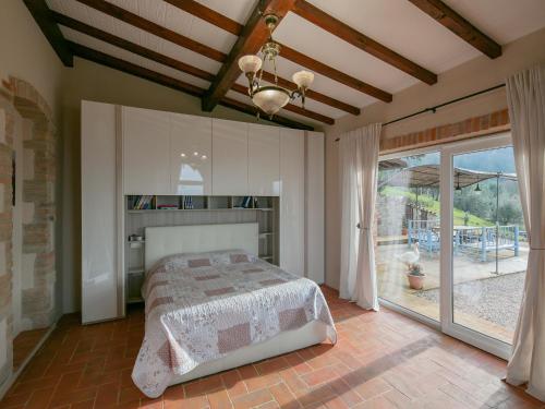 a bedroom with a bed and a large window at Villa in Cortona with Private Pool in Magione