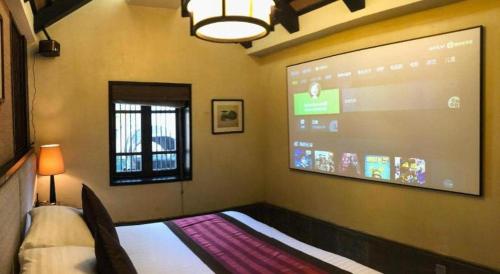 a room with a large projection screen on the wall at Hotel Dayu Kaiyuan in Shaoxing