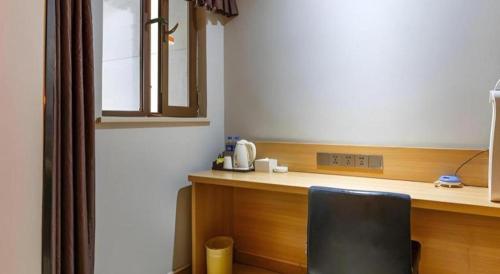 a kitchen with a desk with a black chair in it at 7 Days Premium Xi'an Dayan Tower Xiaozhai Metro Station in Xi'an