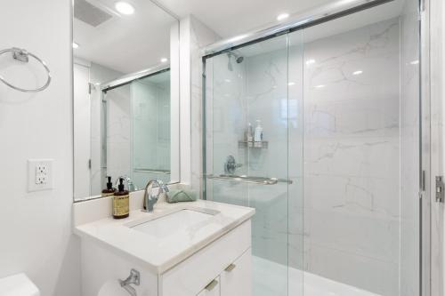 a white bathroom with a sink and a shower at Callister BNB in Vancouver