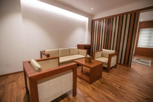 a living room with a couch and a table at Hotel Niya Regency in Trichūr