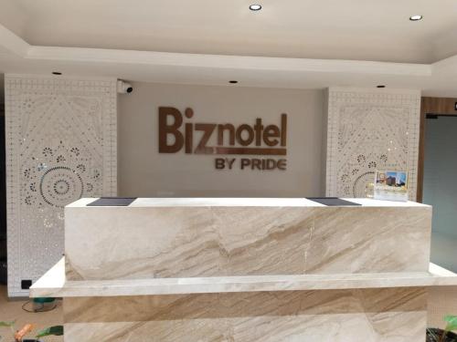 a sign for a bmw store with a marble counter at Biznotel by Pride Surat in Surat