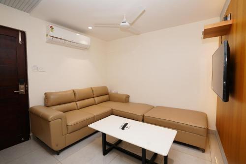 ein Wohnzimmer mit Couch und Tisch in der Unterkunft Hotel ss residency in Vijayawāda