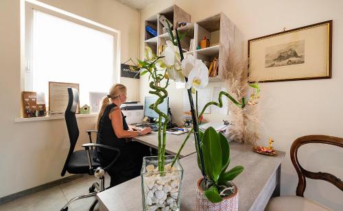 a woman sitting at a desk in an office at Italianflat - FREE parking, Salted Swimmingpool - Casa Ulivi del Garda in Castion Veronese