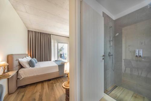 a bedroom with a bed and a glass shower at Italianflat - FREE parking, Salted Swimmingpool - Casa Ulivi del Garda in Castion Veronese