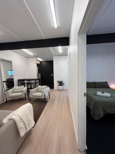 a bedroom with a bed and a living room at WEST HUB. Private Infrared Sauna near city & much more! New purpose built loft style! in Brisbane