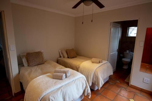 a bedroom with two beds with towels on them at Weavers Nest Guesthouse in Modimolle