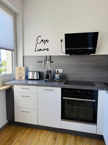 a kitchen with white cabinets and a stove top oven at Casa Lumina - Stilvolles Apartment mit Herz in Schweinfurt