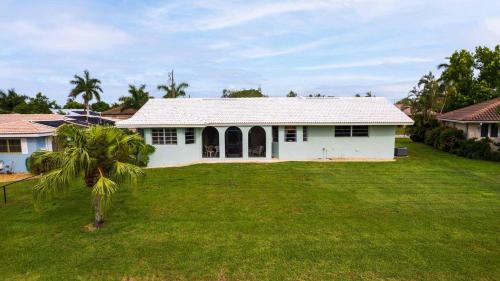 a white house with a palm tree in the yard at GRH11506 - Charlotte Harbor Area - 2 Bed 2 Baths Villa in Punta Gorda Isles