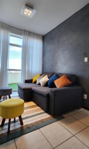a living room with a black couch with colorful pillows at Tranquilidade e Vista Panorâmica - Nova Lima in Nova Lima