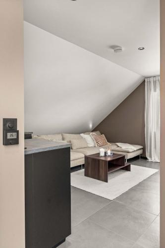 a living room with a couch and a table at Stylish Loft on Bakaroy in Haugesund