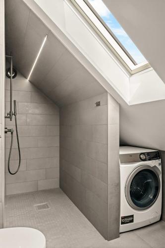 a washer and dryer in a bathroom with a shower at Stylish Loft on Bakaroy in Haugesund