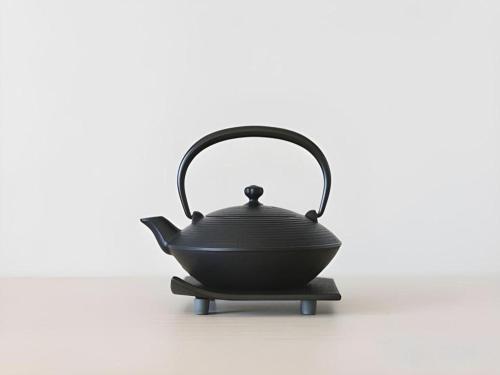 a black tea pot sitting on a stove at Hotel Yaenomidori Tokyo in Tokyo