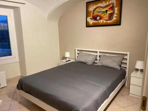 a bedroom with a bed and a painting on the wall at Una finestra sul mondo! in Biella