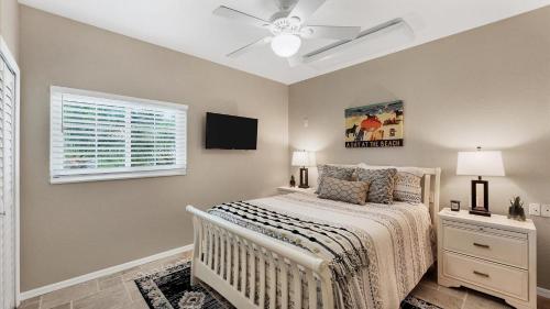 a bedroom with a bed with a ceiling fan and a window at GRH14127 - Charlotte Harbor Area - 3 Bed 2.5 Baths Villa in Punta Gorda Isles