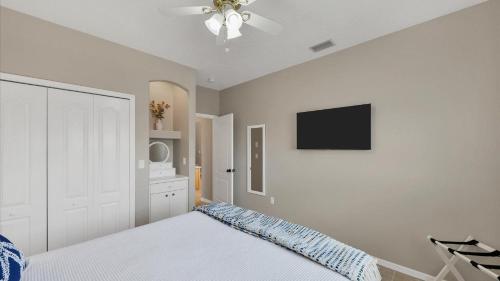 a bedroom with a bed and a flat screen tv at GRH14127 - Charlotte Harbor Area - 3 Bed 2.5 Baths Villa in Punta Gorda Isles