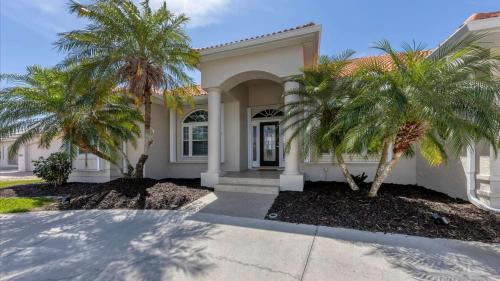 a house with two palm trees in front of it at GRH14127 - Charlotte Harbor Area - 3 Bed 2.5 Baths Villa in Punta Gorda Isles