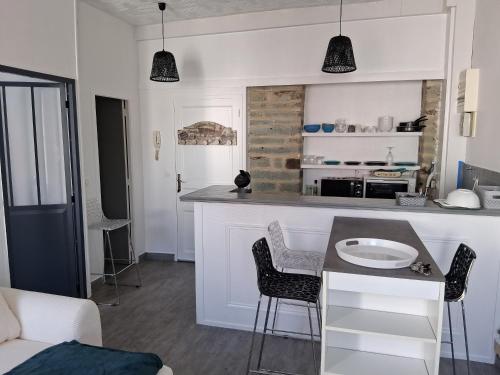 una cucina con bancone, tavolo e sedie di Sweetie Flat a Cherbourg en Cotentin
