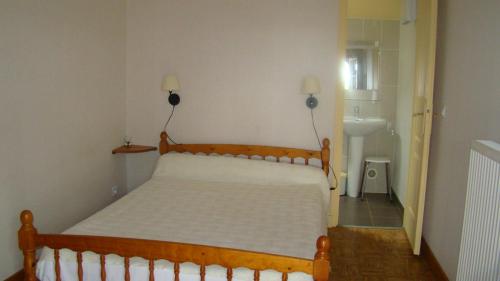 une chambre avec un lit et un lavabo dans l'établissement Chambres d'hotes DES GRAVES, à La Celle-sous-Gouzon