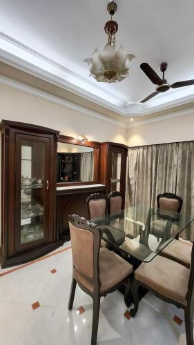 a dining room with a glass table and chairs at Nayra Apartment by Jaiswal House in Kolkata