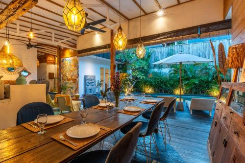 a dining room with a long table and chairs at Villa Shakti Canggu in Canggu