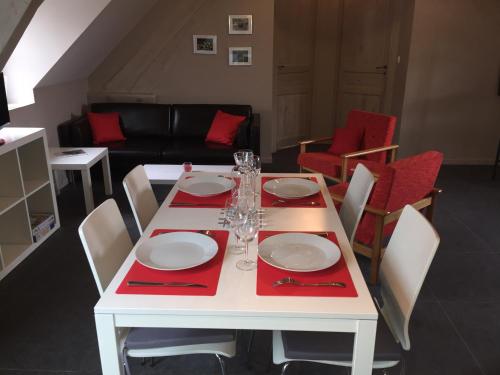 a white table with red napkins and plates on it at Gîtes du Montois in Genech