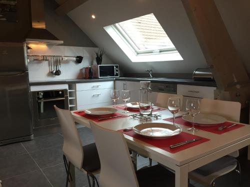 a kitchen with a table with wine glasses on it at Gîtes du Montois in Genech