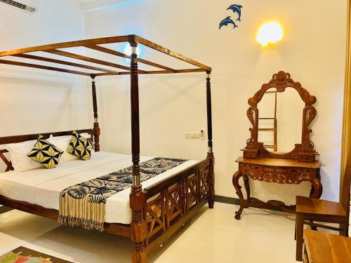 a bedroom with a canopy bed and a mirror at Lucky Beach Mirissa in Mirissa