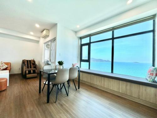 a living room with a table and a view of the ocean at Seahome Beachfront Apartment - Mường Thanh Viễn Triều Nha Trang in Nha Trang