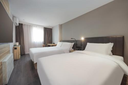 a hotel room with two beds and a television at Hanting Hotel Beijing Xisanqi Dongsheng Technology Park in Beijing