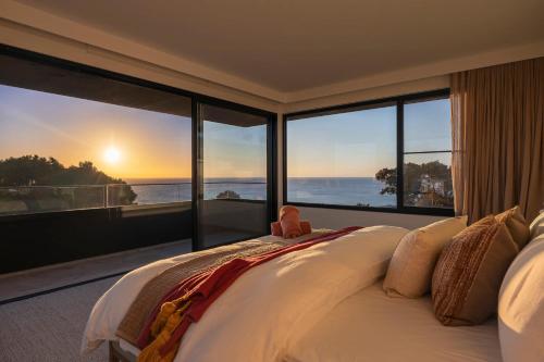 a bedroom with a bed with a view of the ocean at Blanc de Noir Luxe Grandeur with Pool and Spa in Mount Martha