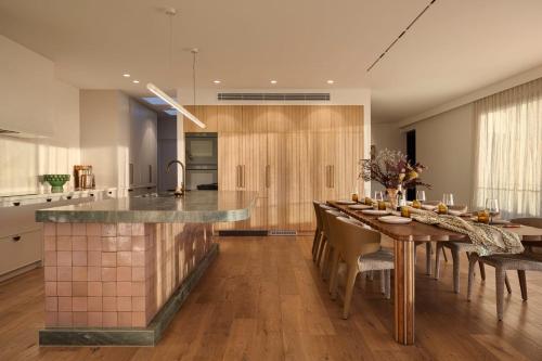 a kitchen with a long table with chairs and a counter at Blanc de Noir Luxe Grandeur with Pool and Spa in Mount Martha