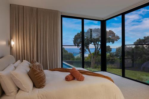 a bedroom with a white bed with a large window at Blanc de Noir Luxe Grandeur with Pool and Spa in Mount Martha