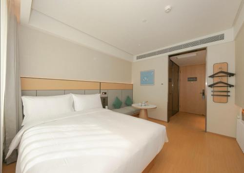 北京市にあるJI Hotel Beijing Wangfujingのベッドルーム1室(大きな白いベッド1台付)、廊下が備わります。