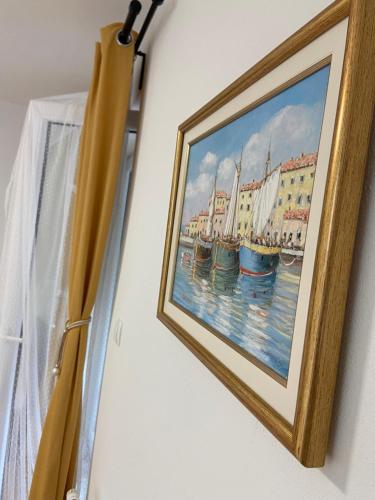 a painting of boats on a wall next to a window at Filuma Suite with private terrace and balcony PANORAMIC GACKA VIEW in Otočac