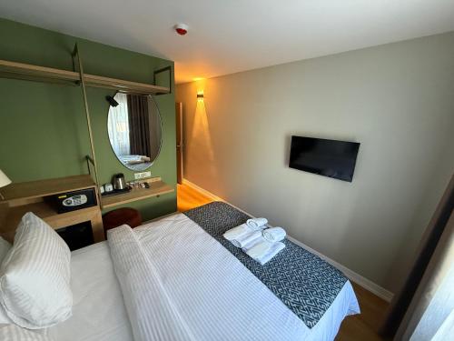 a hotel room with a bed and a tv at OTTO X Hotel in Kavaklıdere