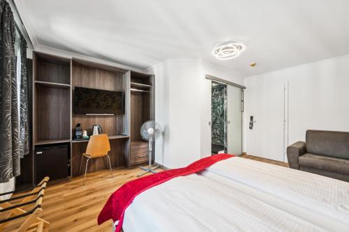 a bedroom with a large bed and a desk at Hotel Sonne Interlaken-Matten in Interlaken