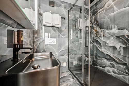 a kitchen with a sink and a glass wall at Hotel Sonne Interlaken-Matten in Interlaken