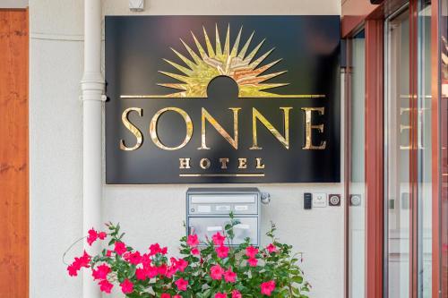 a sign for a somene hotel with pink flowers at Hotel Sonne Interlaken-Matten in Interlaken