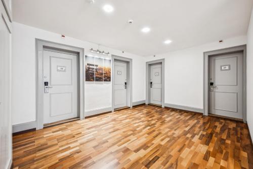 an empty room with four doors and a wooden floor at Hotel Sonne Interlaken-Matten in Interlaken