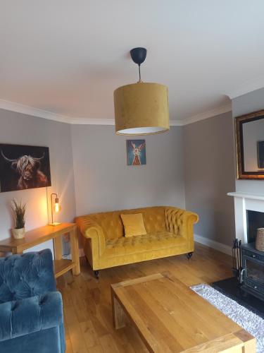 a living room with a yellow couch and a table at Gorgeous 3 bedroomed house 17 sheen view in Kenmare