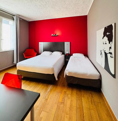 a room with two beds and a red wall at Hotel Italia in Tours