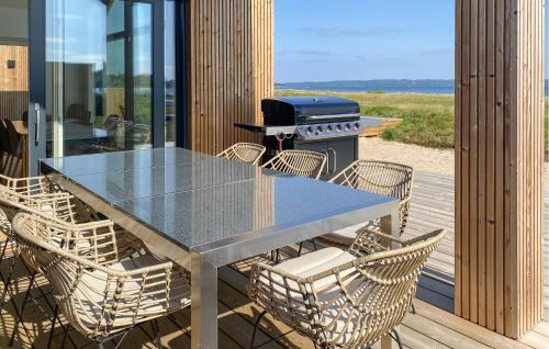 a table and chairs on a deck with a grill at 4 Bedroom Amazing Home In Fredericia in Fredericia