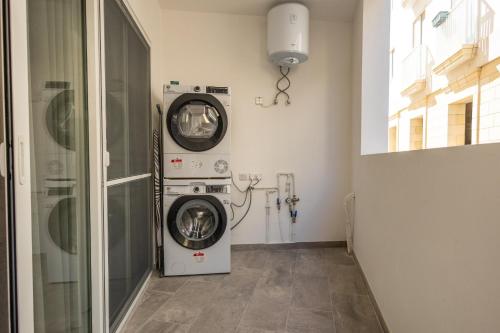 a laundry room with a washer and a washing machine at Downtown Central Apartments in Msida