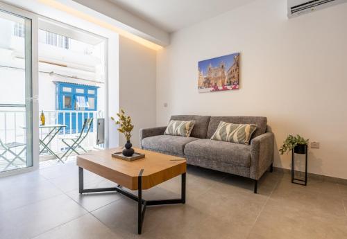 a living room with a couch and a coffee table at Downtown Central Apartments in Msida