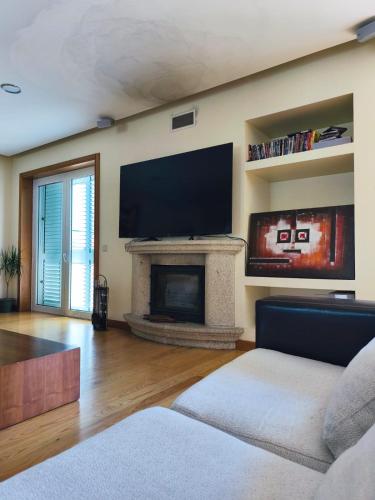 a living room with a fireplace and a flat screen tv at 2 Floors Villa Close Apulia Beach in Esposende