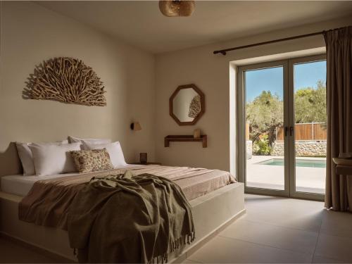 a bedroom with a bed and a sliding glass door at Conte Maris IV in Tragaki