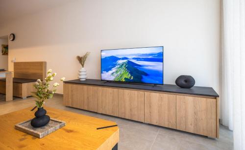 a living room with a flat screen tv on a cabinet at Downtown Central Apartments in Msida