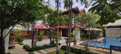 a house with a swimming pool next to a building at Banksy's Siem Reap in Phumĭ Réach Born