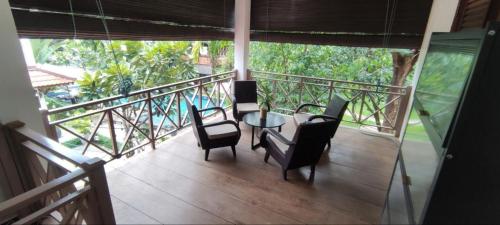 a balcony with a table and chairs on a porch at Banksy's Siem Reap in Phumĭ Réach Born